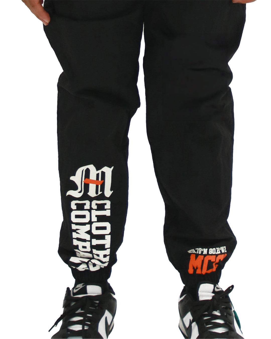 Nylon multi-graphic pants with Miami Clothing Co. logo, elastic waistband, and front welt pockets.